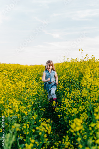 A young girl walks the yellow field