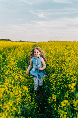 A young girl walks the yellow field