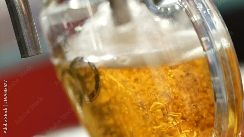 Beer is pouring from the top into the glass forming waves HD