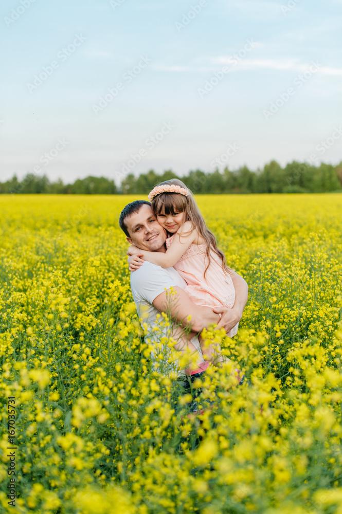Man with child in a yellow field at sunset Man with child in a yellow field at sunset