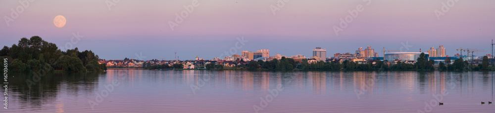 Moon perigee, Belarus. Panoramic View Of Minsk City with fullmoon and picturesque town with colorful buildings Around the coastal zone. Perigee full moon over the skyscrapers of Minsk, Belarus. 