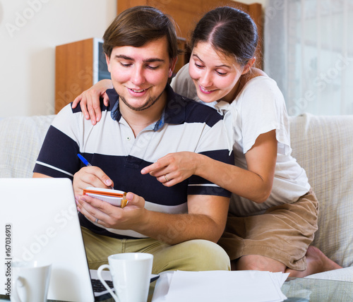couple browsing web and making notes indoors