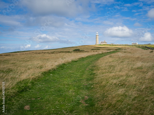 View of the path leading to the lighthouse on the isle of Lundy, off the coast of Devon, UK, on a warm summers day with blue skies.