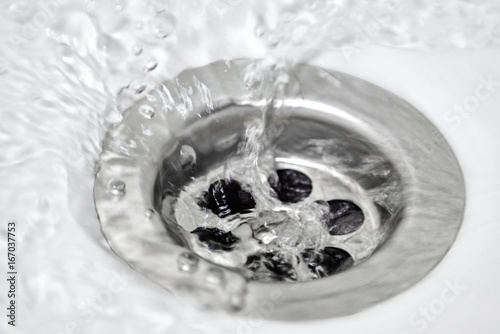 Water flows into the drainage hole with a shallow depth of field