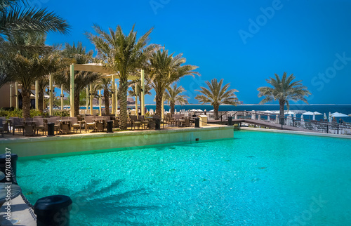 Fototapeta Naklejka Na Ścianę i Meble -  Dubai. Heavenly oasis in Ras al Khaimah. The beach with sunbeds and sunshades in Dubai, on the shores of the Arabian Gulf. Toning.
