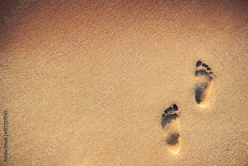 Footsteps on the beach over sand background photo