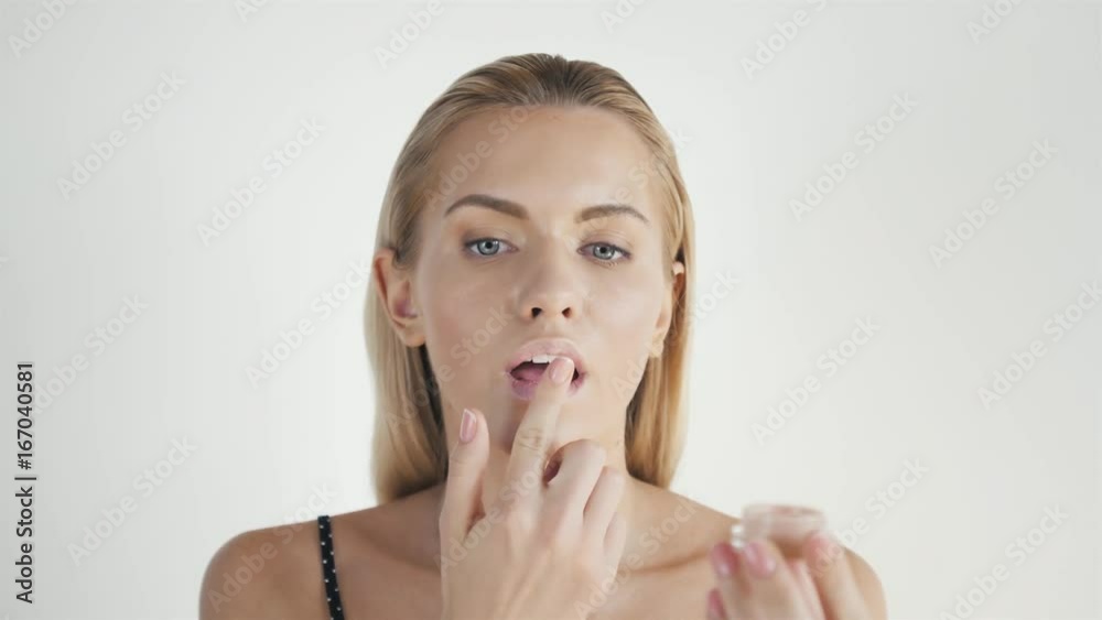 Portrait of happy smiling beautiful young woman touching skin or applying cream, after shower with towel on head Portrait of happy smiling beautiful young woman touching skin or applying cream, after shower with towel on head