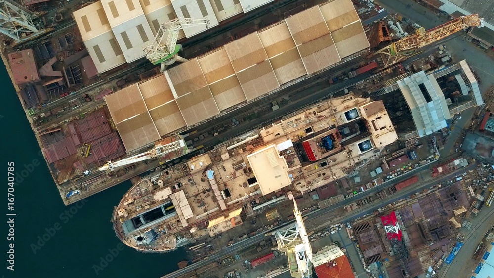 Aerial top down view of unfinished ship at the shipyard