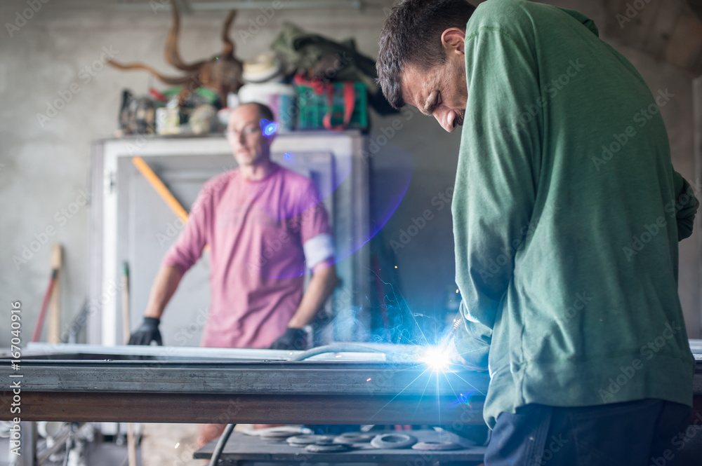 Obraz premium Industrial worker welding the steel structure in the workshop