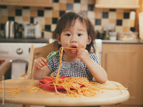 baby girl eating messy spaghetti photo