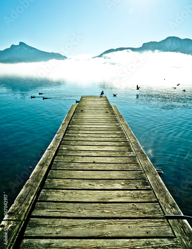 View on Pier with seagulls by mountain lake Mondsee in Autria