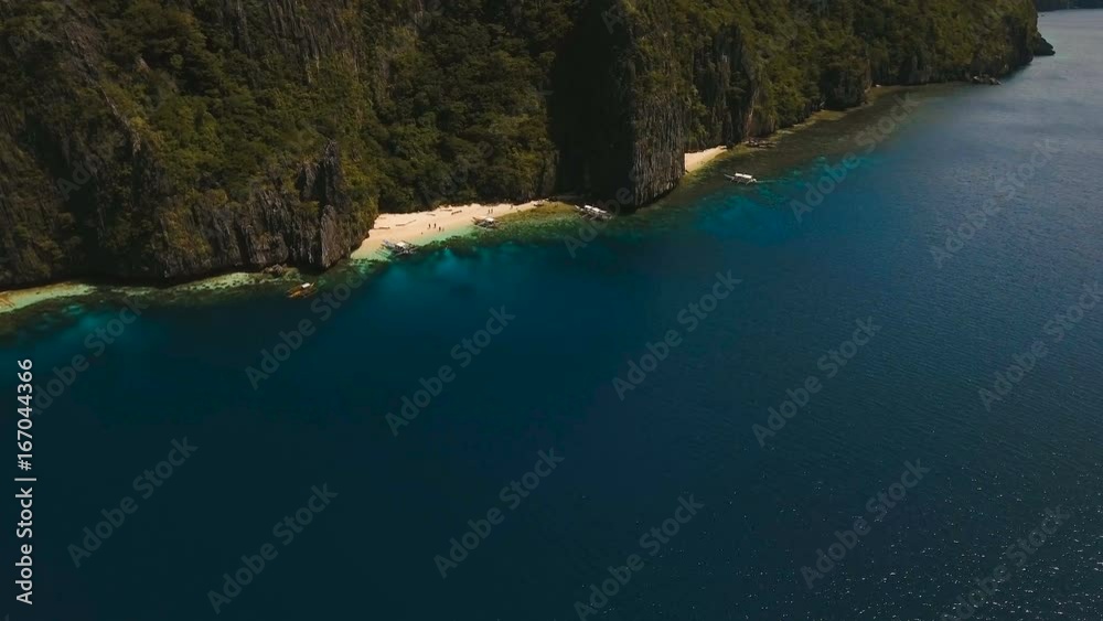 Tropical lagoon with turquoise water and white sand. Blue Lagoon with tourists and motor boats. Beautiful beach. Tropical bay in El Nido. Aerial view: bay and the tropical island. Aerial video Tropical lagoon with turquoise water and white sand. Blue Lagoon with tourists and motor boats. Beautiful beach. Tropical bay in El Nido. Aerial view: bay and the tropical island. Aerial video