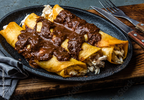 Wallpaper Mural Mexican cuisine. Traditional Mexican chicken enchiladas with spicy chocolate salsa mole poblano. Enchiladas with sauce moole from Puebla, Mexico Torontodigital.ca