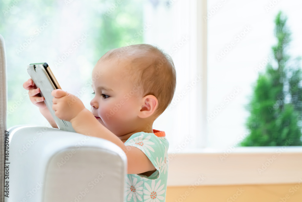 Toddler girl watching a tablet computer in her house Toddler girl watching a tablet computer in her house