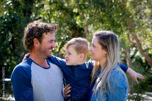 Tableau sur toile Father, Mother and young son together outdoors in sunlight in park