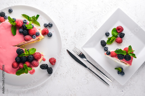 Cake with butter and fresh berries and fruits. Dessert. On a wooden background. Top view. Free space for your text.