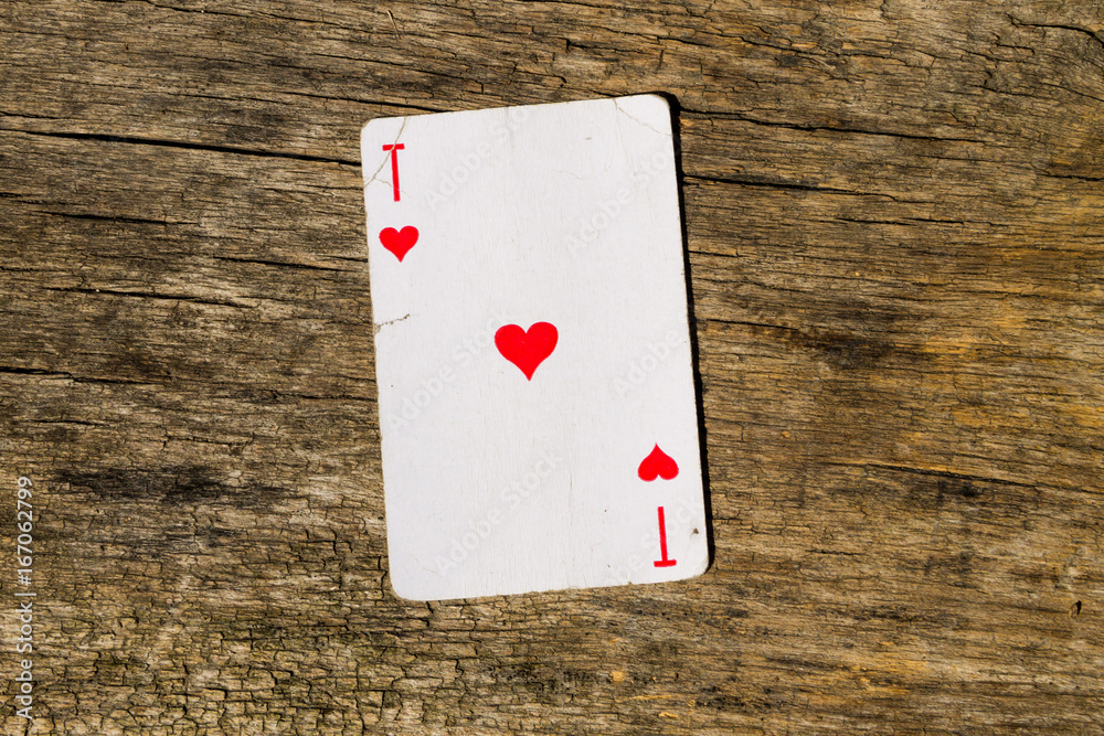Ace of hearts on old wooden background