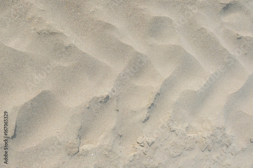 A frontal close up of tractor tire tracks on beach sand. Shot from directly above