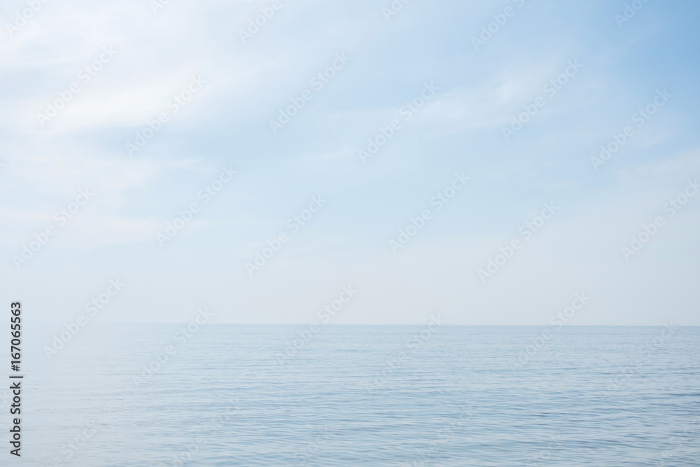 Calm tranquil blue sea with no waves and with foggy backgroudn Calm tranquil blue sea with no waves and with foggy backgroudn