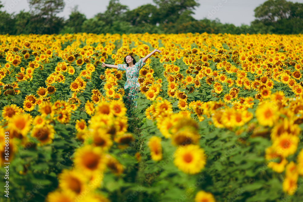 Brunette girl in a field of sunflowers