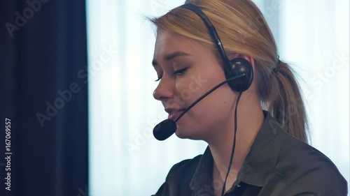 Female customer support operator with headset talking and smiling
