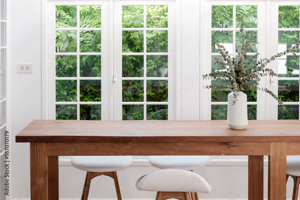 Εκτύπωση καμβά Wooden table and chairs in white room, pot plant, with windows and garden outside for concept of home office, work from home, desk in living room / home desk