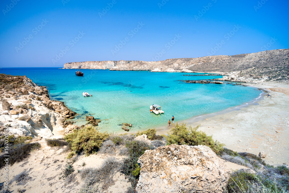 Amazing view of Koufonisi island with magical turquoise waters, lagoons, tropical beaches of pure white sand and ancient ruins on Crete, Greece Amazing view of Koufonisi island with magical turquoise waters, lagoons, tropical beaches of pure white sand and ancient ruins on Crete, Greece