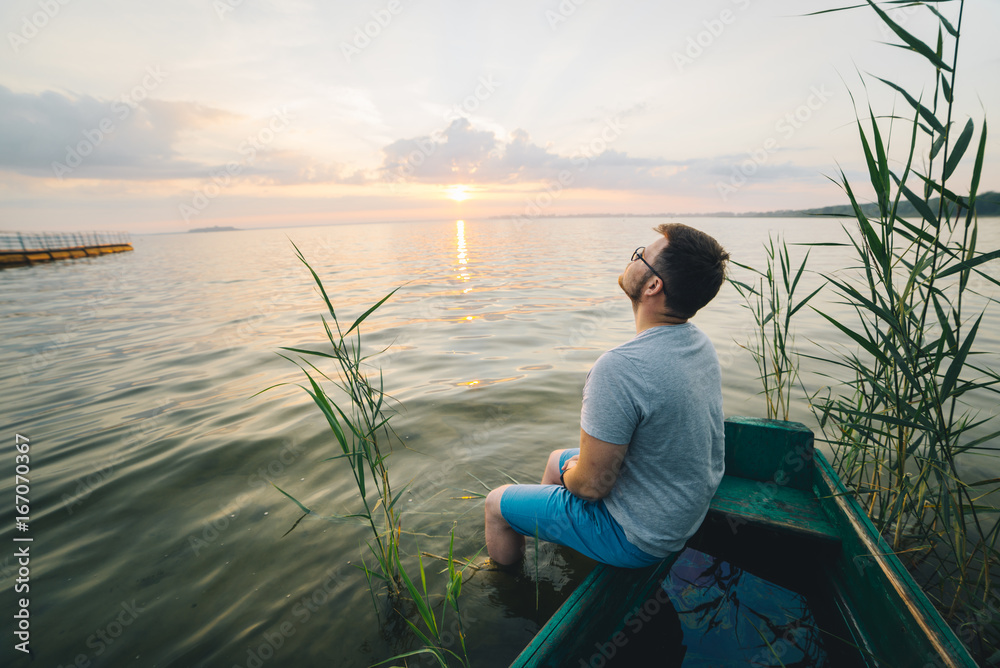 Fototapeta premium man sitting in the old boat thinking