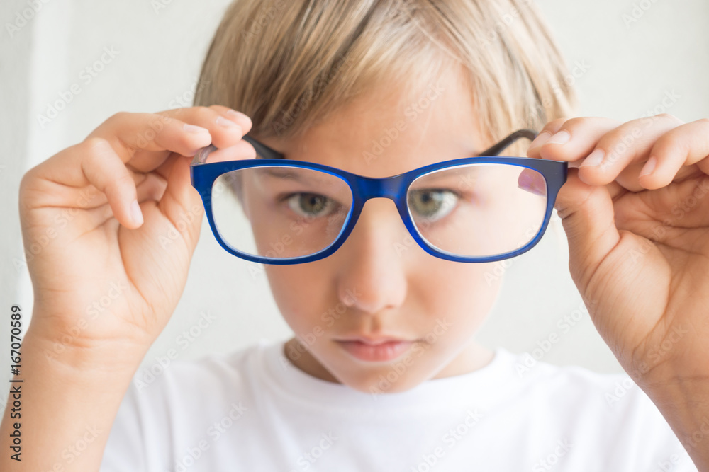 Boy holding glasses and looking through it Boy holding glasses and looking through it