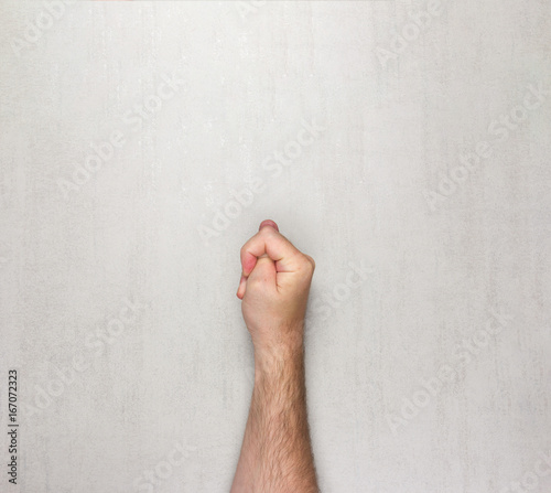 hairy men hand shows the gesture of a Fig on a grey background. mock up for text, phrases, lettering