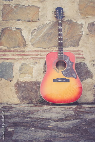 Gitarre lehnend auf Steinmauer photo