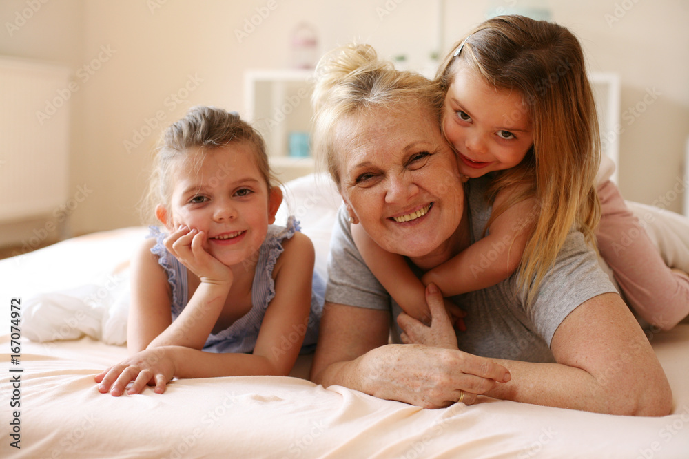 Grandmother playing in bed with her granddaughters. Grandmother playing in bed with her granddaughters.