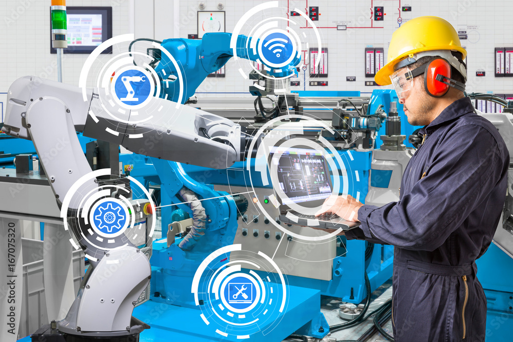 Engineer using laptop computer for maintenance automatic robotic hand machine tool at industrial manufacture factory Engineer using laptop computer for maintenance automatic robotic hand machine tool at industrial manufacture factory