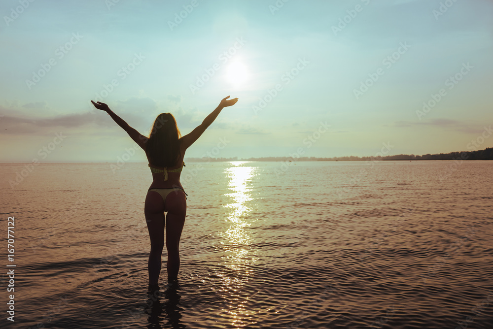 Fototapeta premium woman standing on the beach in sweemuit with sexy ass