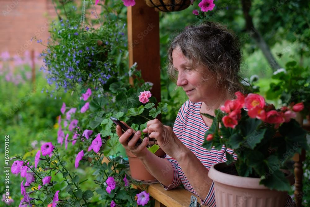 Mature woman calling on phone and looking at flowers