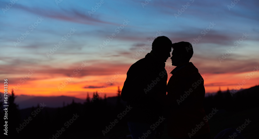 Close-up silhouettes of a loving couple of hikers kissing on top of the mountain copyspace love anniversary achieving togetherness affection romantic hiking active