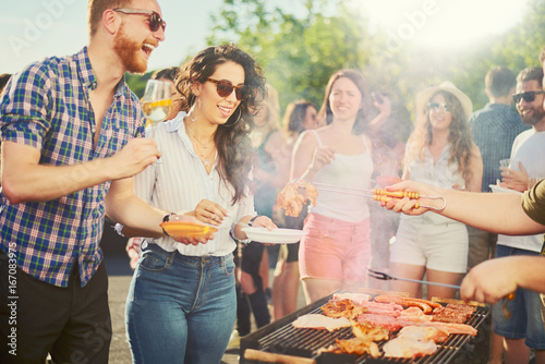 Print op canvas Couple standing and drinking alcohol at barbecue party