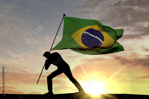 Brazil flag being pushed into the ground by a male silhouette. 3D Rendering