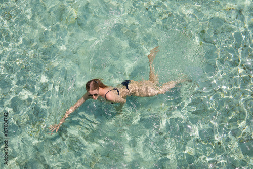 Young girl swimming in a turquoise water.