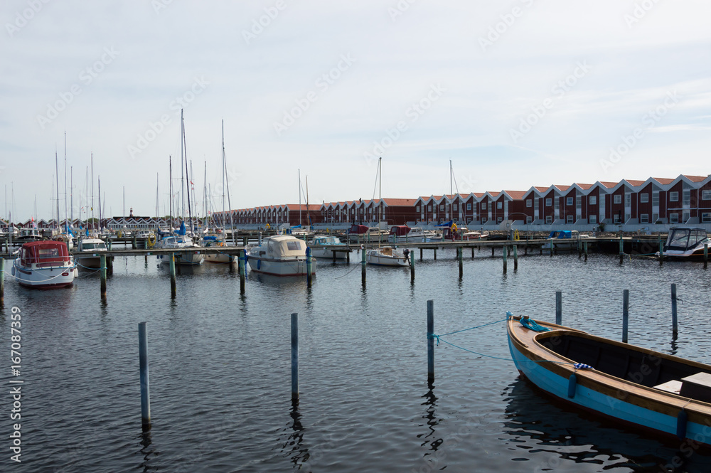 Denmark, Northern Jutland, Nibe. The towns marina/harbor with typical red wooden danish buildings and ships.
