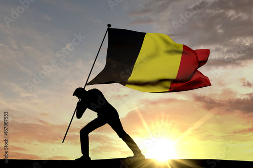 Belgium flag being pushed into the ground by a male silhouette. 3D Rendering