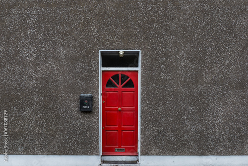 Red door and rough texture stone wall background