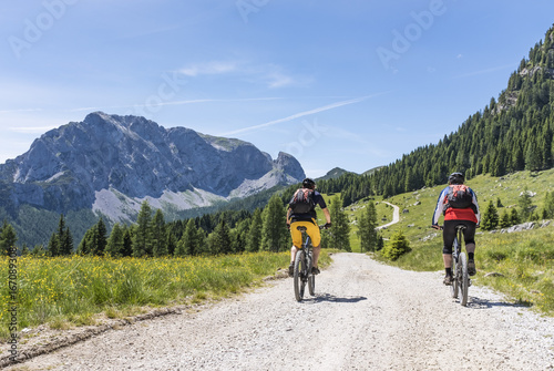 Two mountainbiker in Carnic Alps with view to mountain Rosskofel