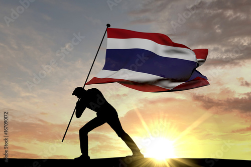 Thailand flag being pushed into the ground by a male silhouette. 3D Rendering