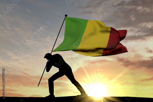 Mali flag being pushed into the ground by a male silhouette. 3D Rendering