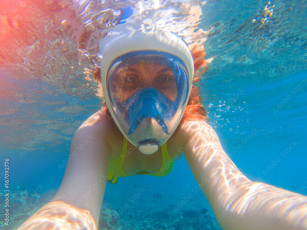 Fototapeta premium Snorkel girl underwater selfie. Snorkeling in full face mask. Summer activity.