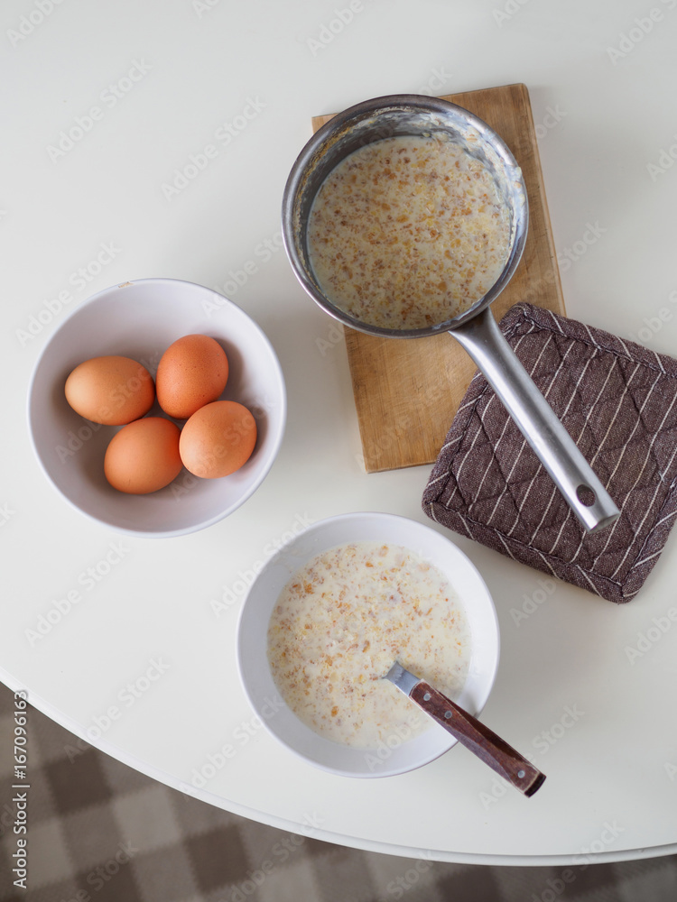 Breakfast with oatmeal and eggs. White table Breakfast with oatmeal and eggs. White table