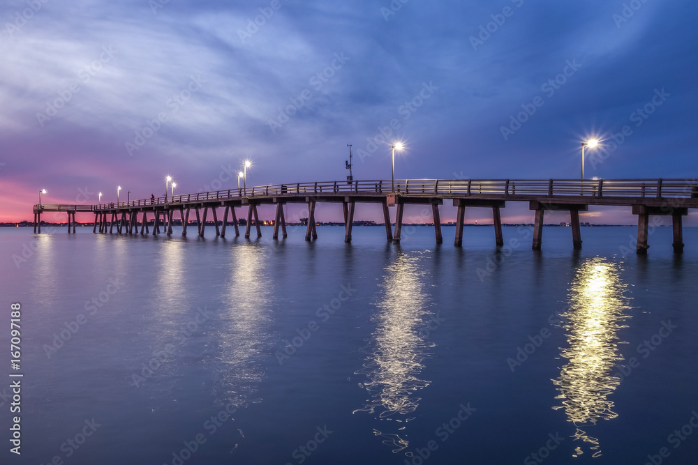 Fishing pier at dusk with dramatic sky