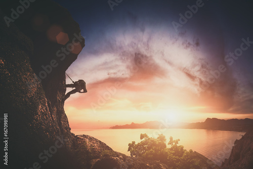Climber on a rock against sunset. Instagram stylization