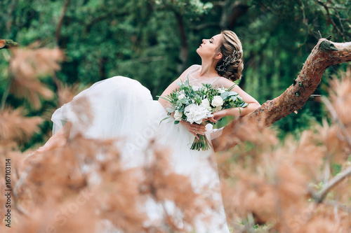 Fototapeta Naklejka Na Ścianę i Meble -  Beautiful bride in the nature in a luxurious dress